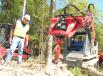 Fecon’s Bob Candee (L) looks on as Neal Ashburn, Power Equipment Company forestry machine specialist, operates a Takeuchi TL10 compact track loader with a Fecon Stumpex stump grinding attachment.