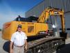 Eddie Gardner, regional sales manager, Sany, Peachtree City, Ga., stands with this new Sany  SY215C.
 