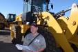 Marcel Morin, owner of Morin & Farms, Saint David, Maine, was very interested in this Caterpillar 938M wheel loader and was checking the auction book for more info.
