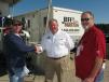 Jeff Martin (C) gives a warm welcome to his friends and customers, including John Tindal (L), Tindal Truck Sales, Mayfield, Ky., and Charles Whitney, a land development contractor based locally in Brooklyn, Miss.