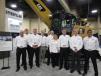 (L-R): Caterpillar’s Justin Folwz, Pou Fabrizius, Todd Benson, Garry Monaghan, Ken Felcyn, Danielle Livengood, Vincent Migeotte, George Pinther and Hugo Pravena, introduce the Cat MH3026 purpose-built material handler with orange peel grapple. This model replaces the MH3024. 