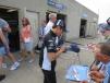 Takuma Sato, driver of the #30 car, signs autographs in the garage area. 

