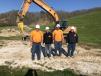 (L-R): Dwane Byrd, Mark Bollinger, Robert Fortner and Travis Carey, all of Byrd Construction, get to work using this Case CX210B with a hammer.  