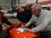 Randy Eckstein (R), Kubota sales specialist with Lano Equipment in Shakopee, Minn., signs a deal for this Kubota 4WD BX235 compact tractor for Mike Melchior, who will use the machine on his property to remove rocks, trees and snow.
 