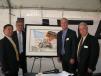(L-R): To commemorate the day, an original commissioned painting of the Hitachi wheel loader with the stars and stripes was presented to Masaaki Hirose, president of Hitachi Construction Machinery Loaders America Inc. Making the presentation to Hirose are Kotaro Hirano, Al Quinn and David Agan.  