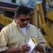 Jesus Ramirez, owner of Vesco Tractors in Gadsden, Ala., checks his notebook at an equipment auction.
 