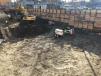 Skid steer loaders assist in smoothing the floor of the construction site. 