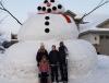 Eric Fobbe and his family pose in front of the 20 ft. snowman they created beside their home.
 