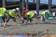 Talladega Superspeedway’s future President (current vice president, marketing and sales) Brian Crichton (L) assists construction crews in spreading the final sections of the last concrete pour for the flooring of the Open Air Social Club in August.