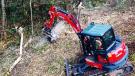 The demonstration Kubota KX057-4 mini-excavator with FAE forestry mulching head attachment makes quick work of felling and mulching trees.