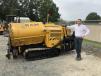RAM Pavement President Rob Miller poses with a Weiler P265 commercial paver sold to him by Carolina Cat.