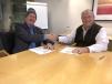 Kevin O’Donnell (L), president of Bergmann Americas Inc., shakes hands with Ascendum Machinery president and CEO Kenny Bishop after signing on the dotted line.