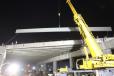 Here, a beam is about to be placed on a new bridge. Night work was essential on the busy freeway.