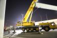 Here a mobile crane is lifting a heavy steel beam to placed on a bridge being repaired.