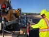 A worker adjusts the Vogele paver’s screed to help maximize smoothness for the finished track.