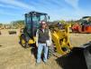 Ryan Cunningham, used equipment manager, Laurel Machinery, Latrobe, Pa., stands in front of a Caterpillar 906M wheel loader.