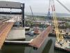 Cranes are playing an essential role in the bridge reconstruction project. Here one lifts a prefabricated deck.