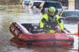 An inflatable raft brings a rescue worker through the flooded downtown streets of New Brunswick, N.J., in the aftermath of Tropical Storm Ida.