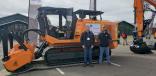 Cascade Trader booth, Chehalis Wash., with Mike Samples (L), territory manager of FAE, and Angus Brunoff, sales and rental coordinator, with the tree-chewing FAE PT-300, the ideal tracked carrier for the most difficult tasks, whether managing woods and forests or creating firebreaks near electrical lines. 