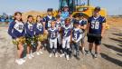 Chargers quarterback Justin Herbert poses with a youth football and cheer team in front of a Cat 950H wheel loader at the groundbreaking ceremony.
(Courtesy of Los Angeles Chargers) 