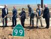Six state and local officials dig dirt with ceremonial shovels behind the new “California 99” State Highway Route sign.
(Caltrans photo) 