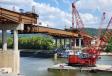 The main span, five beams wide, 11 ft. tall, and 314 ft. long, was pre-assembled and lifted into place from a barge in the middle of the Kanawha River. The section of bridge weighs about two million pounds. 