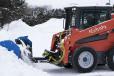 If plowing snow on paved surfaces which are frequently cleared, and the snow is fairly loose, wheeled skid steers with snow tires are the best solution.
(KAGE photo) 