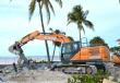 A Case CX220E excavator works to remove slabs from the flood ravaged Lynn Hall Memorial Park visitors center and beach facilities on Ft. Myers Beach.   (CEG photo)