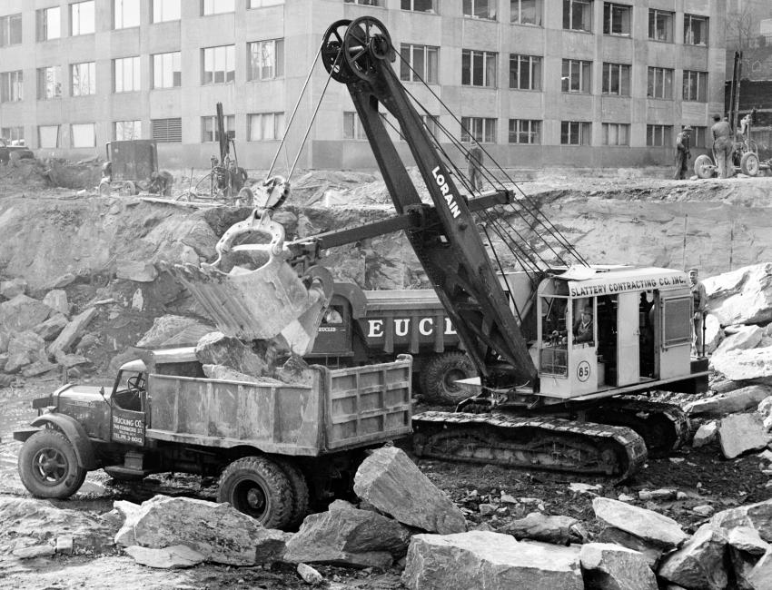 Author’s Photo Collection
A Lorain 820 shovel with a 2 cu. yd. (1.5 cu m) dipper loads a for-hire Sterling single axle chaindrive dump truck with blasted rock. A 10 ton (9 t) Euclid end dump on a demonstration is waiting to be loaded.