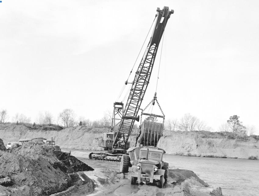A Bucyrus-Erie 88-B equipped with a dragline bucket was loading borrow into a fleet of Euclid bottom dumps. The material was obtained from the Groton Reservoir, thereby increasing its capacity. The photo was taken Oct. 30, 1963.
(CTDOT photo)