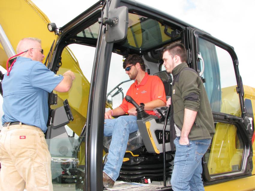 Yancey demonstration operator Matthew Hyde (L) goes over the operation of the Next-Gen Cat excavator with Dru Goodwin (C) and Trevor Bishop of McCoy Grading, Greenville, Ga.   

