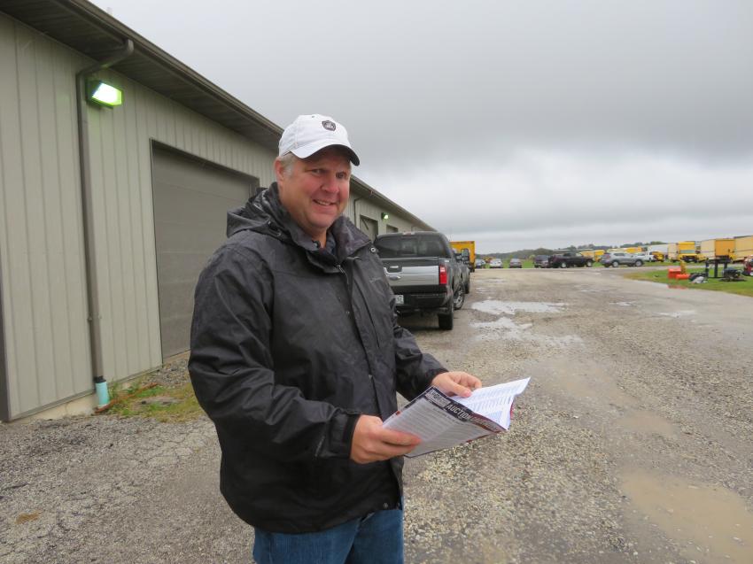 Mike Garrard of Midwest Equipment Group LLC goes over the auction catalog prior to the start of the sale.
