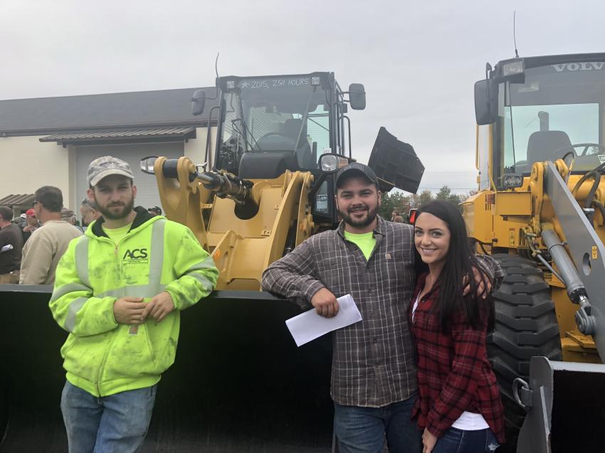 (L-R): Benjamin Mitchell of Barry, Mass., and Derek Carroll and Ashley Bard, both of All Construction Services, Gilbertsville, Mass., stand in front of a 2015 Cat 914K that would wind up being sold to a bidder in Ohio.