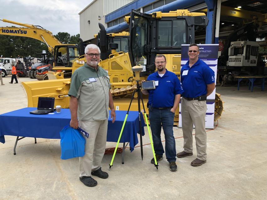(L-R): Steve Davis, Wright McKinley Forestry in Beulaville, N.C., and Vernon Williams and Tim McKenna, both with Linder, look over the automated blade control device for Komatsu dozers.