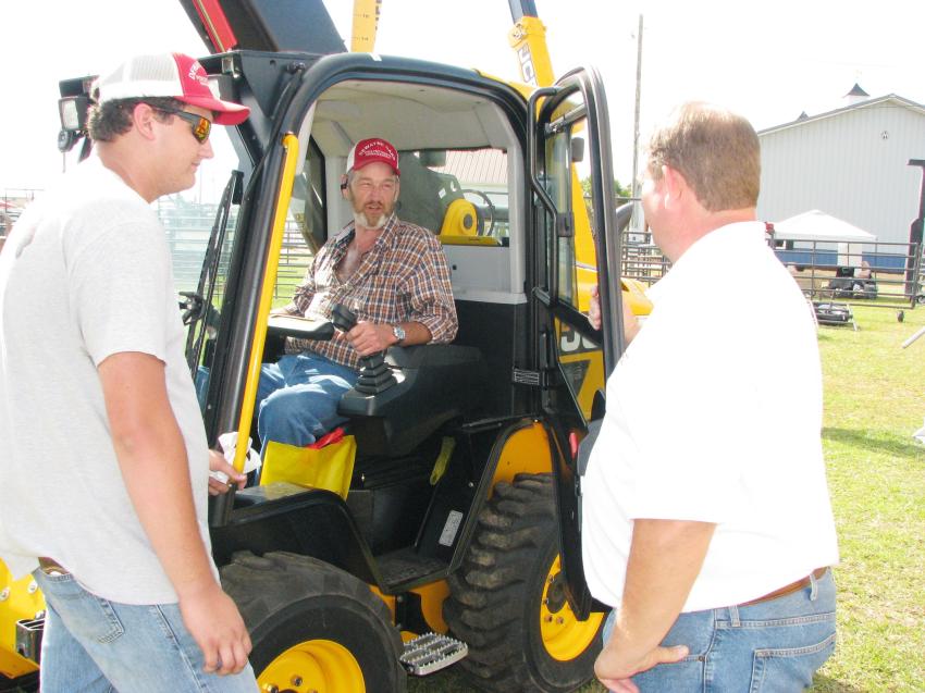 Neil Rountree (R) of MacKinnon JCB, Tifton, Ga., talks with the guys from Dewayne Oaks Poultry Waste Management, based in Eva, Ala., about the advantages of utilizing a JCB Teleskid in their operations. 