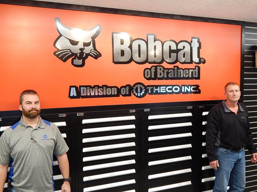 Bobcat of Brainerd service manager Ben Collins (L) and parts manager Bill Feyereisen stand before the company sign at the recently expanded facility.
