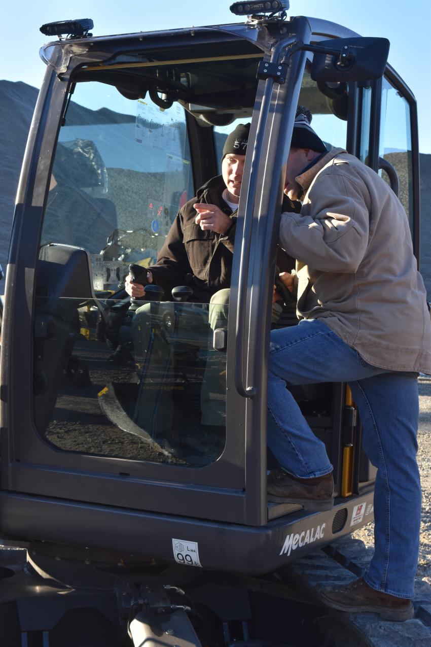 Jim Capiobianco, sales representative of Lorusso Heavy Equipment, reviews the controls of the Mecalac 8-MCR with Joe Chabot, equipment operator of Catalano Construction, Cumberland, R.I.
