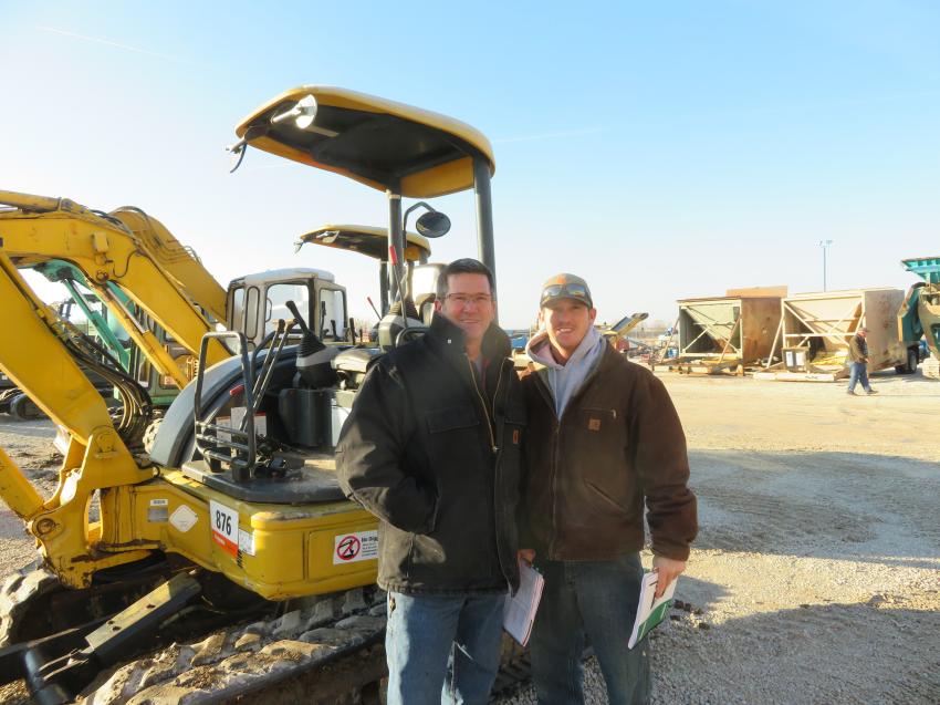 Jeff and Tyler Willis of Capital Paving walk the yard to look at some of the paving equipment.
