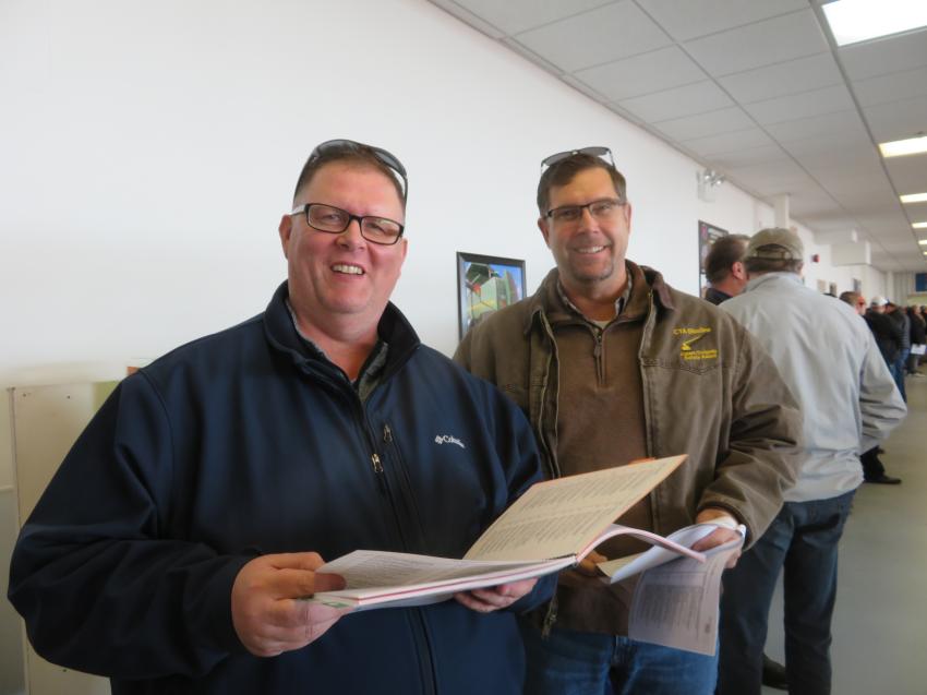 Troy Miller, general service manager, and Jason Zeibert, president, both of Finkbiner Equipment Co., review the sales catalog.
