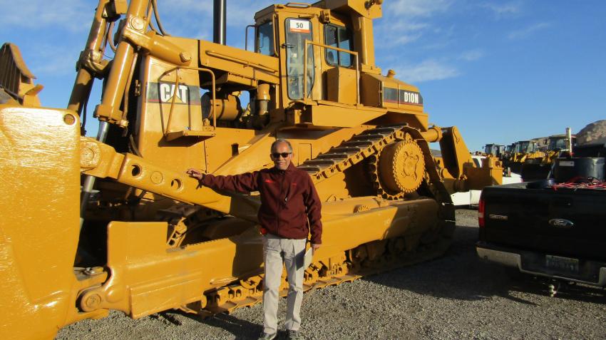 With a clipboard in hand, Eddie Morales of Heavy Equipment Transportation in Tolleson, Ariz.,
 measures dimensions
 of this 1988 Cat 
D10N for transport. 
