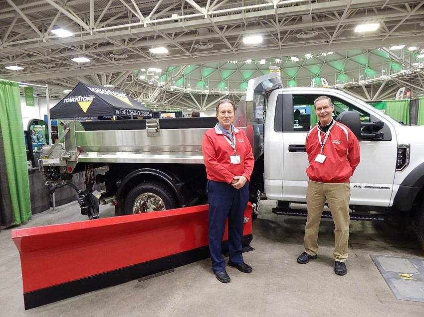 Jeff Hippert (L), North Central sales manager of Monroe Truck Equipment, Monroe Wis., and Jim Schneider, national sales manager of Monroe’s truck equipment division, stand in front of the company’s combo medium duty snow removal package with salt spreader and wing plow.  
