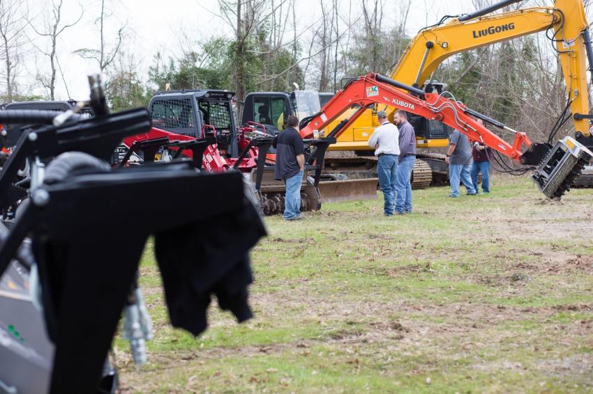Ryan Smith of FAE USA discusses FAE forestry mulchers with a customer among a Kubota KX080 excavator, a Takeuchi TL12V2 skid steer and a LiuGong 925E excavator, all equipped with FAE attachments.