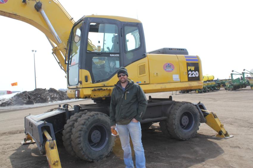 Travis Witzel, Witzel Construction, Langdon, N.D., looks over a wheeled Komatsu PW 220 excavator. Witzel bought a packer, a dozer and a backhoe at the auction and intended to put them all to work as soon as the ground was ready.

