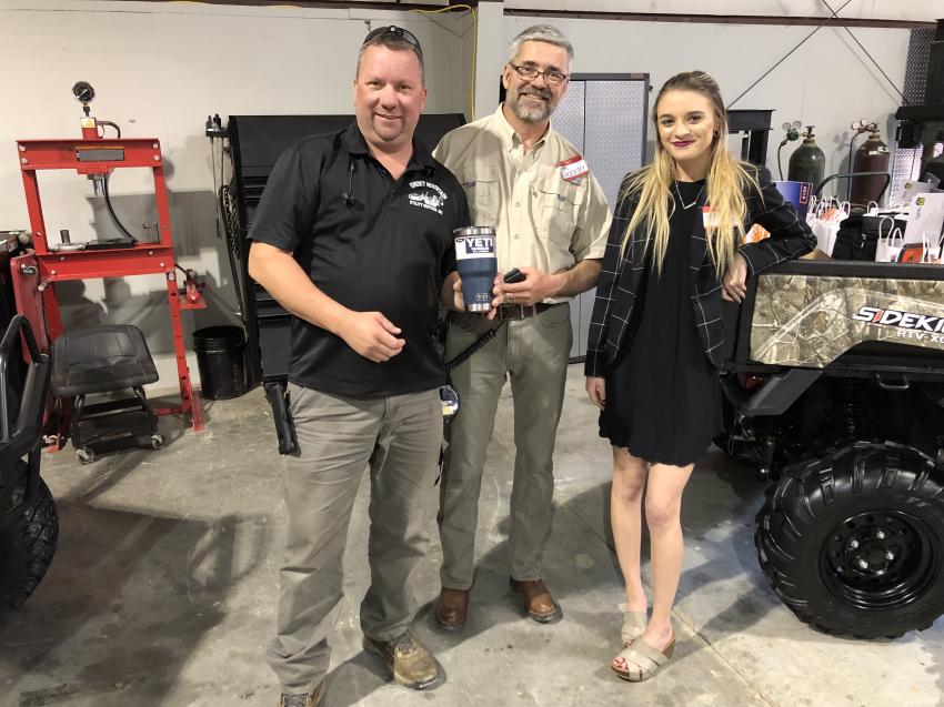 Brent Brown (L), Smoky Mountain Utility Services in Gatlinburg, Tenn., shows off one of the many door prizes RJV Equipment gave away to show customers its appreciation. With him are Chris (C) and Logan Alexander of RJV Equipment.