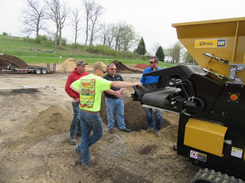 In the foreground, Ohio CAT’s Kyle Bodkins reviews the SMI 90TS’ functions with (L-R) Shannon Wright of Wright Landscape Supply & Marketplace, and Scott Wagner and Matt Brinkman of Screen Machine Industries.
