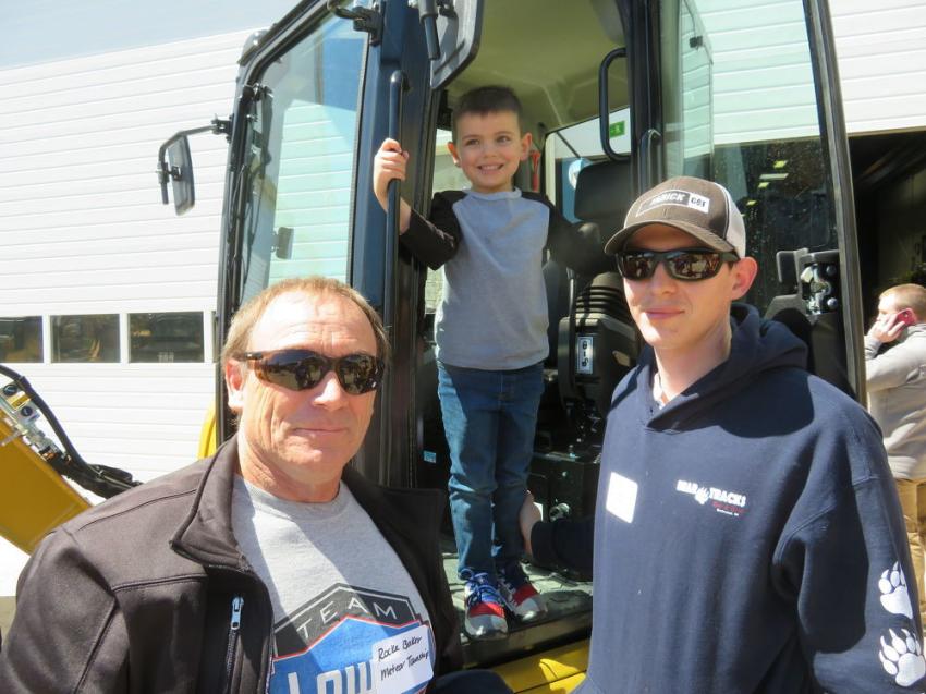 Rocky Baker (L), township of Meteor, and Matthew Riedell of Lac Courte Oreilles Public Works evaluate a Cat 303.5 mini-excavator with the assistance of young Deacon Riedell.