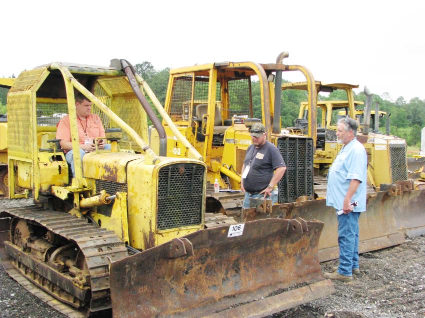 The aged iron are still highly sought out machines. Looking at a few older pieces in the sale are (L-R): Richie Miska (in cab), Big Iron Equipment Sales, Meridian, Miss.; Jeremey Anderson, Waynesboro, Miss.; and Charles Whitney, Charles Land Development, Brooklyn, Miss.
