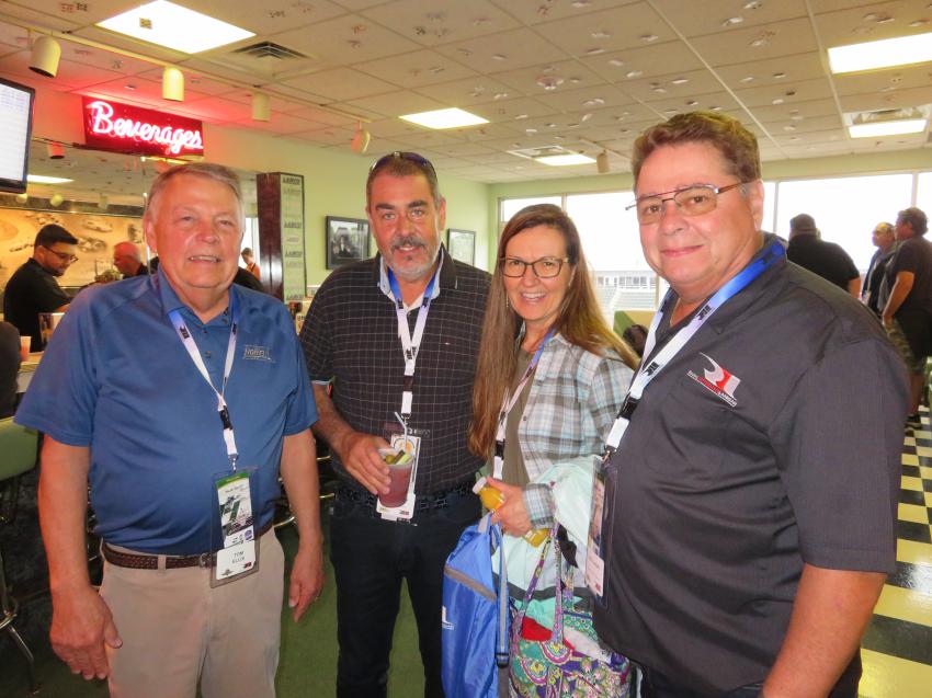 Tom Ellis (L) and Phil Linoski (far R), both of Howell Tractor, welcome Mark and Linda Dokey of Heavy Metal Scrap Inc. to the #34 Mi-Jack Suite.
