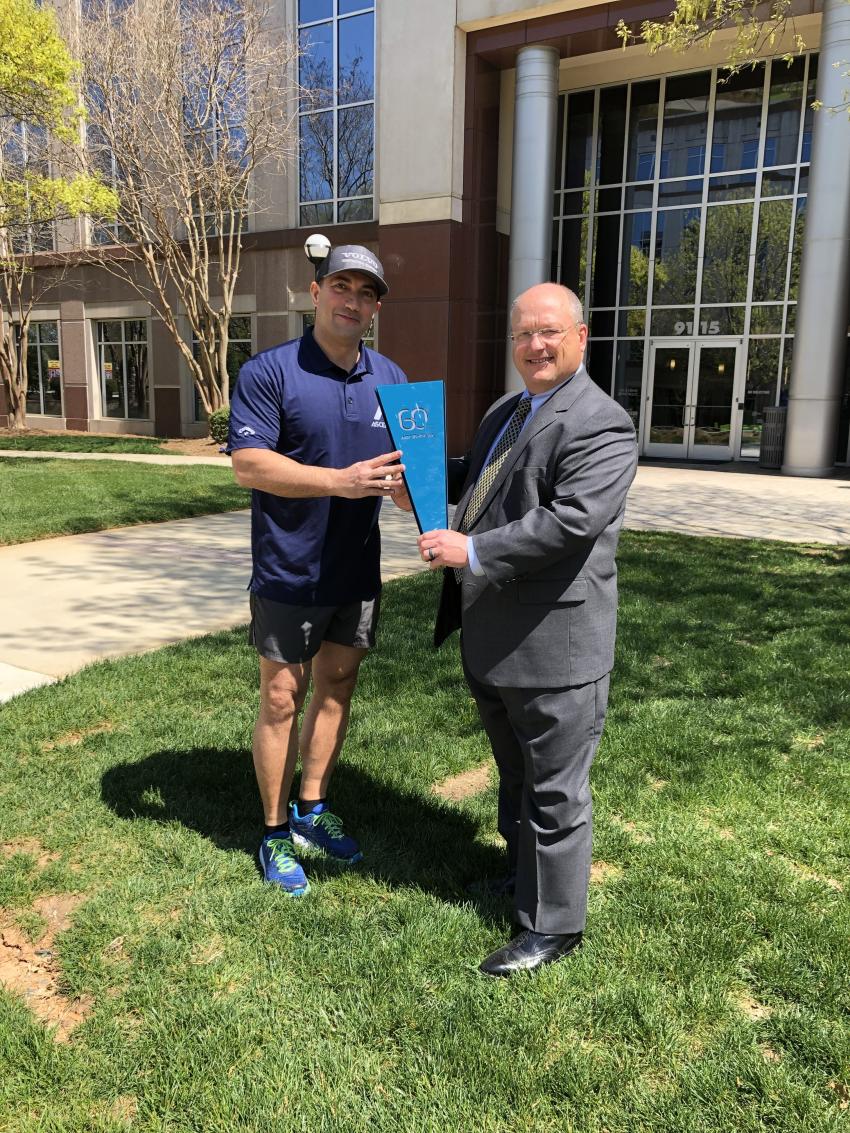 Kenny Bishop, CEO of Ascendum Machinery, hands the torch to Mario Stoilovich, director of business development, to run the 60-year torch from Ascendum’s Corporate offices to the Charlotte branch.
