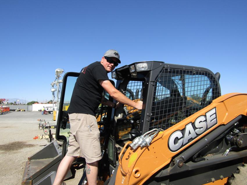 Devon Harwood of Las Vegas climbs into this 2017 Case SV280 skid steer to inspect before bidding starts. 
